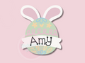 Easter egg-shaped name tag with bunny ears on a pink background